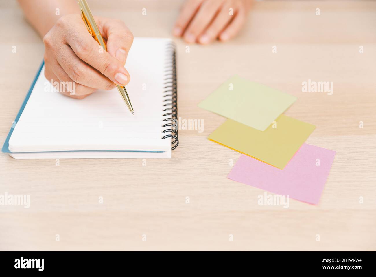 Business professional preparing notes in a spiral notebook beside ...