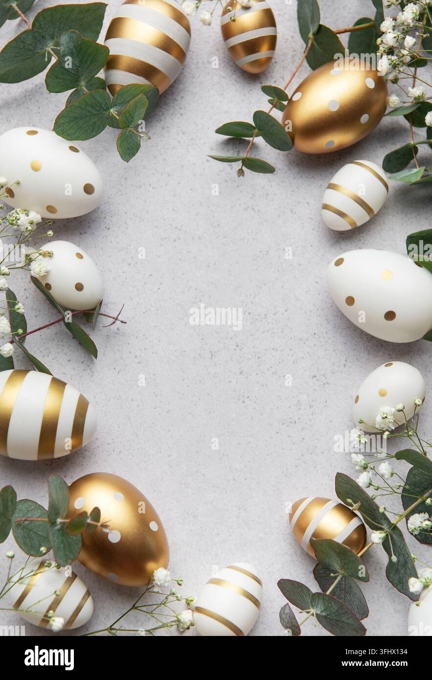 Easter eggs with gold and white decorations forming a frame on a gray background Stock Photo