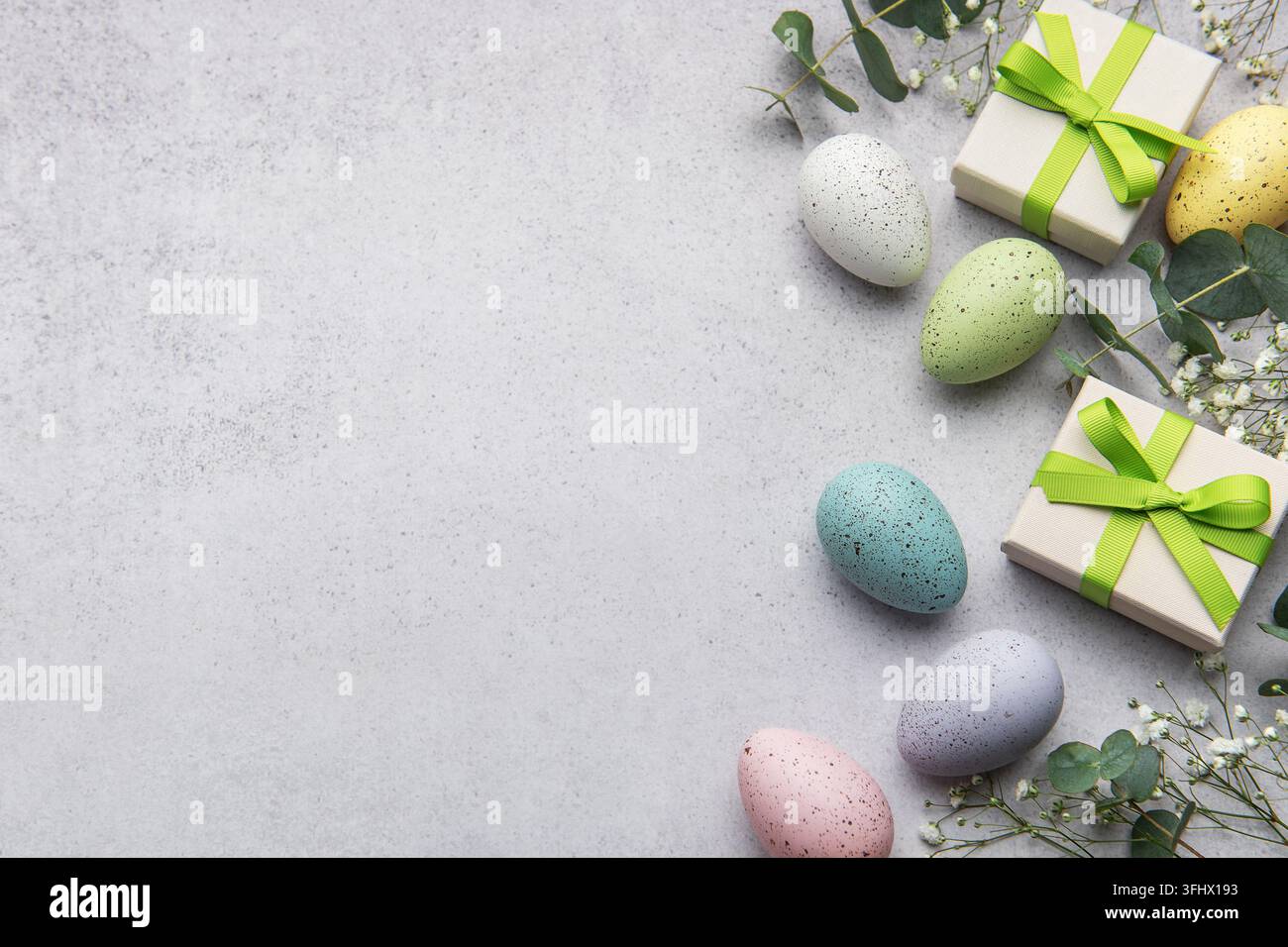 Colorful easter eggs and gift boxes with greenery Stock Photo