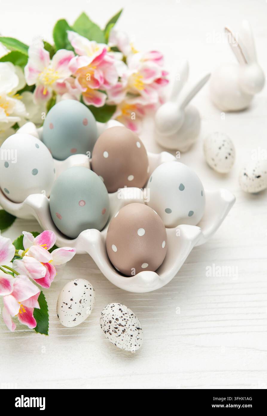 Easter eggs with spring flowers and ceramic bunnies celebrating easter sunday Stock Photo