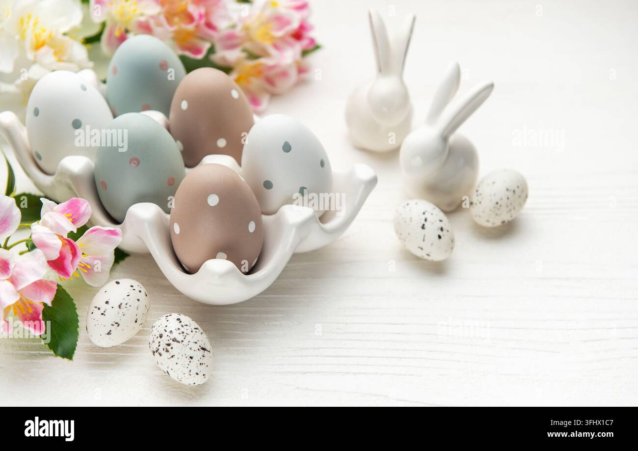Easter eggs with spring flowers and ceramic bunnies celebrating easter sunday Stock Photo