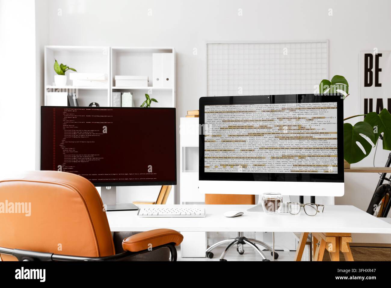 Software development and coding, programmer workspace with dual monitors displaying source code in a modern home office environment Stock Photo