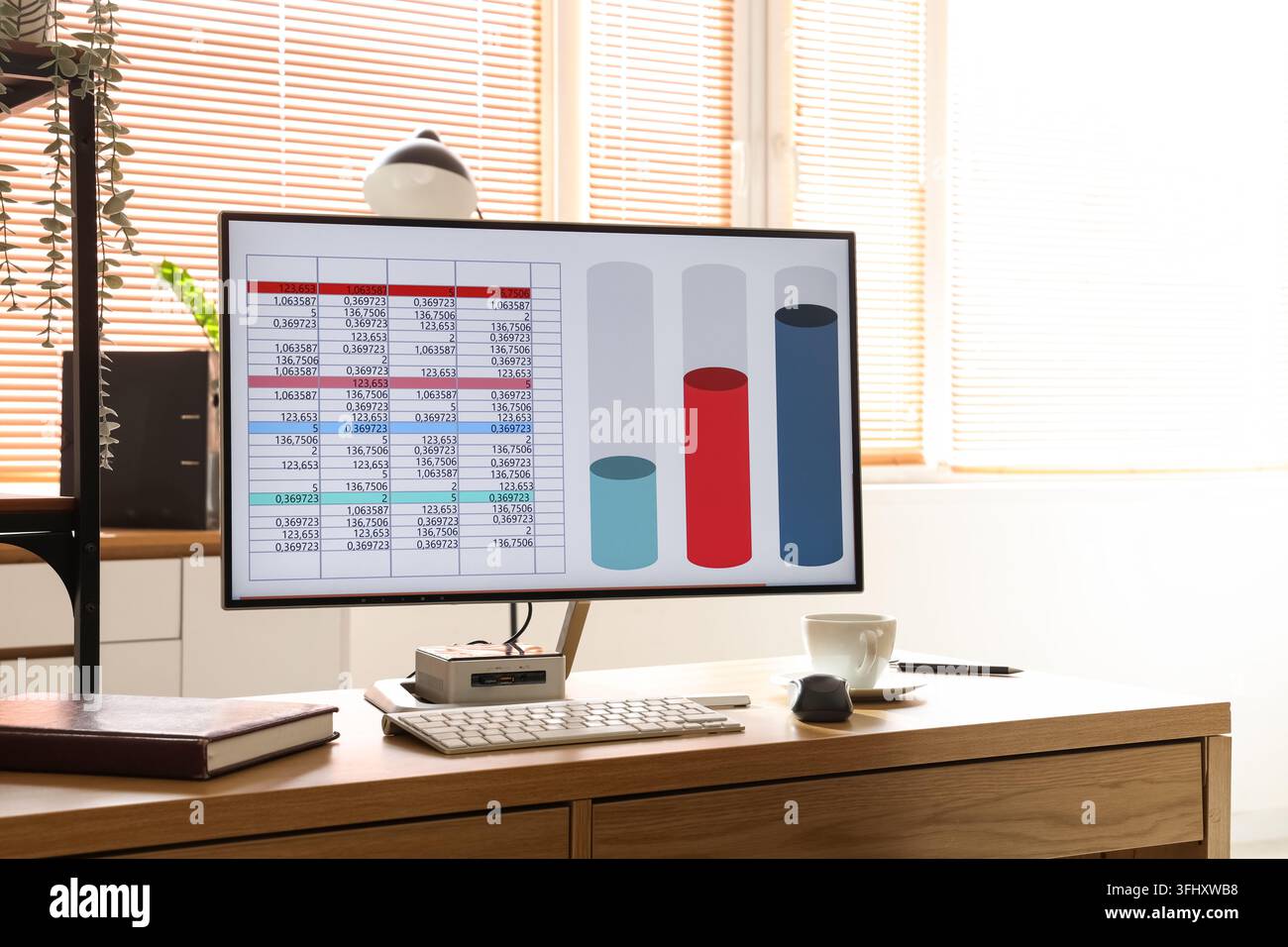 Computer with chart on desk in data scientists office Stock Photo