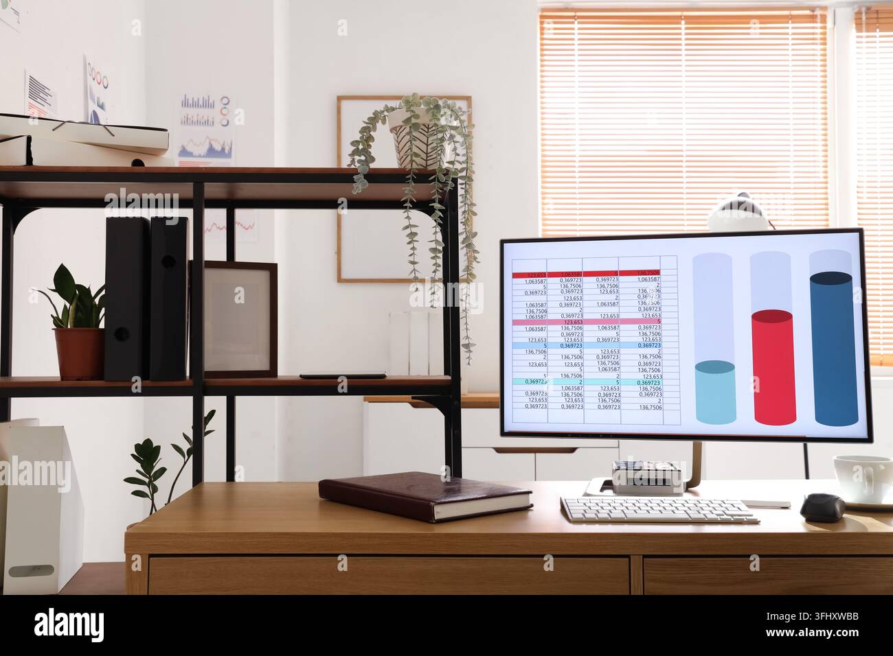 Computer with chart on desk in data scientists office Stock Photo