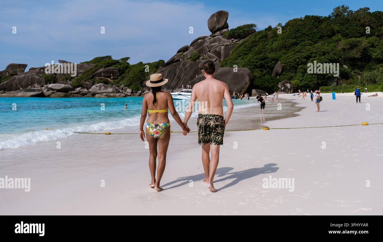 Couple enjoying a romantic walk on the pristine beaches of the Similan Islands in Thailand Stock Photo