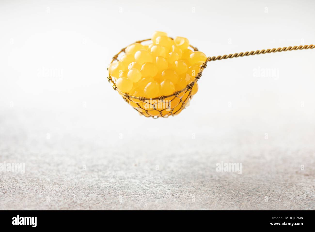 Orange juice balls or popping boba in strainer. Ingredient for trend drinks Stock Photo