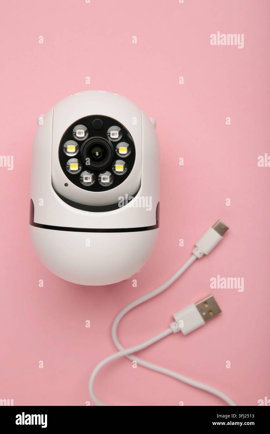 Security camera on pink background. Outdoor surveillance camera. Top view Stock Photo