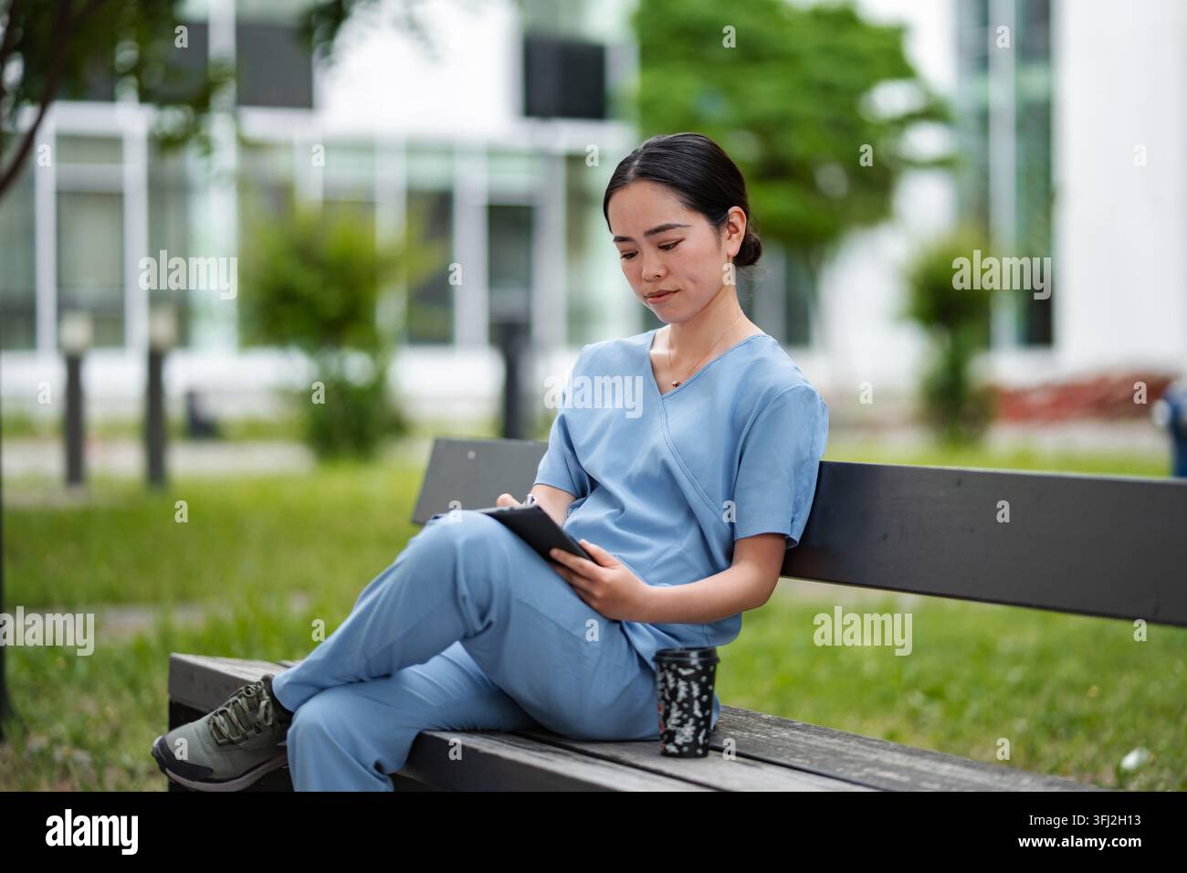 Female medical professional using digital tablet on bench Stock Photo