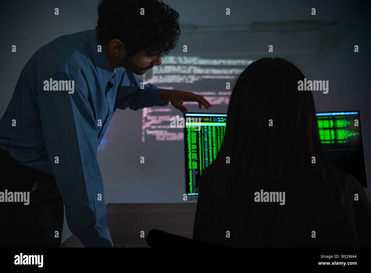 Software engineers collaborating on cybersecurity monitoring and AI powered code analysis Stock Photo