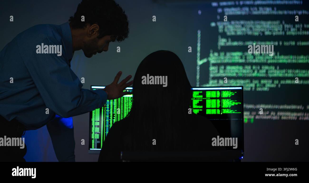 Software engineers collaborating on cybersecurity monitoring and AI powered code analysis Stock Photo