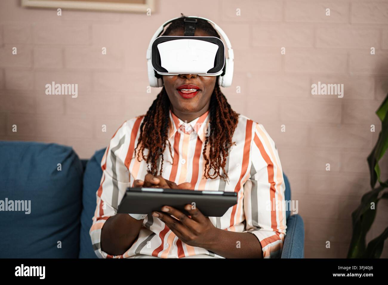 Woman wearing VR headset and using digital tablet Stock Photo