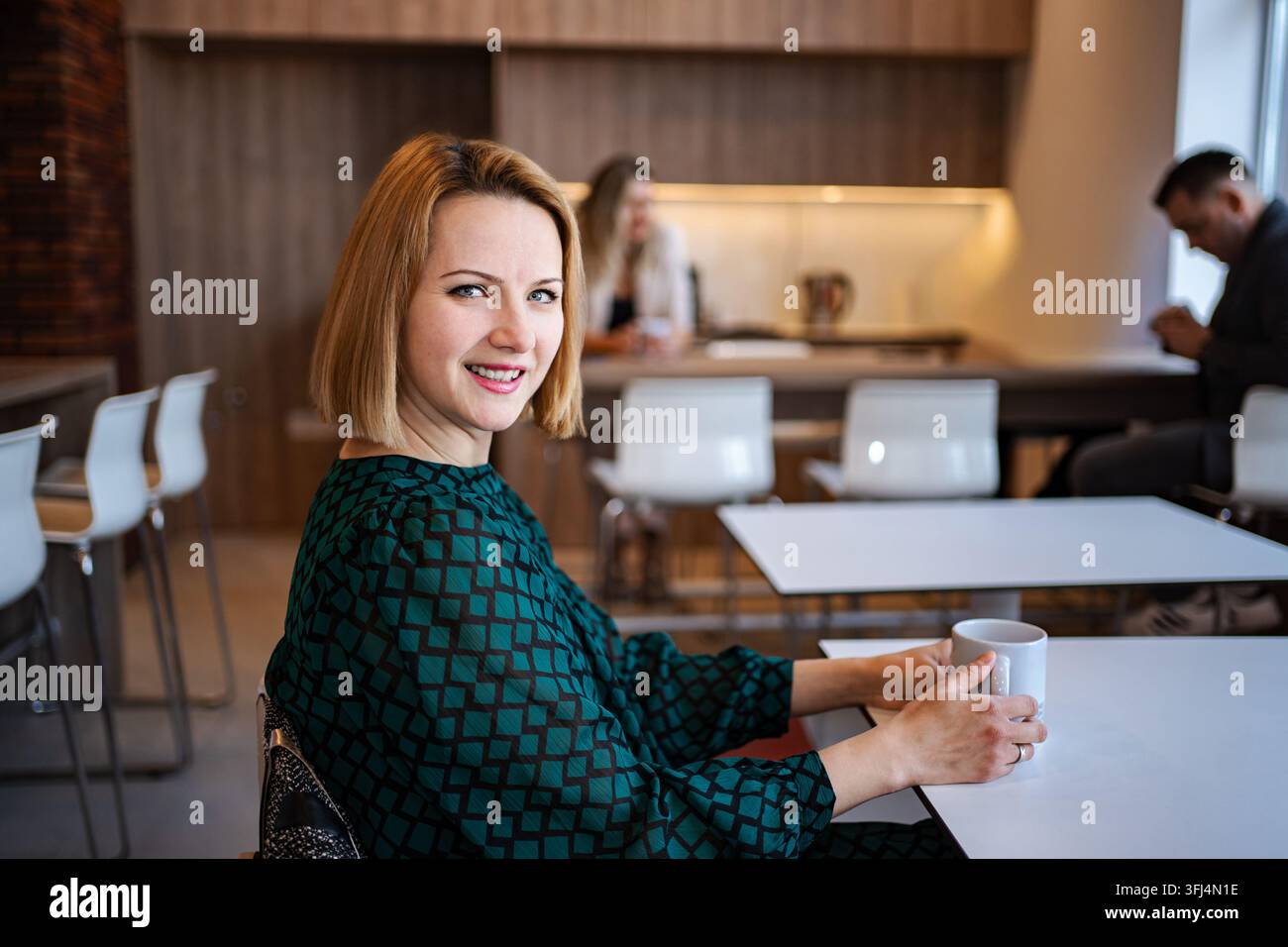 Smiling business woman having coffee break in office Stock Photo