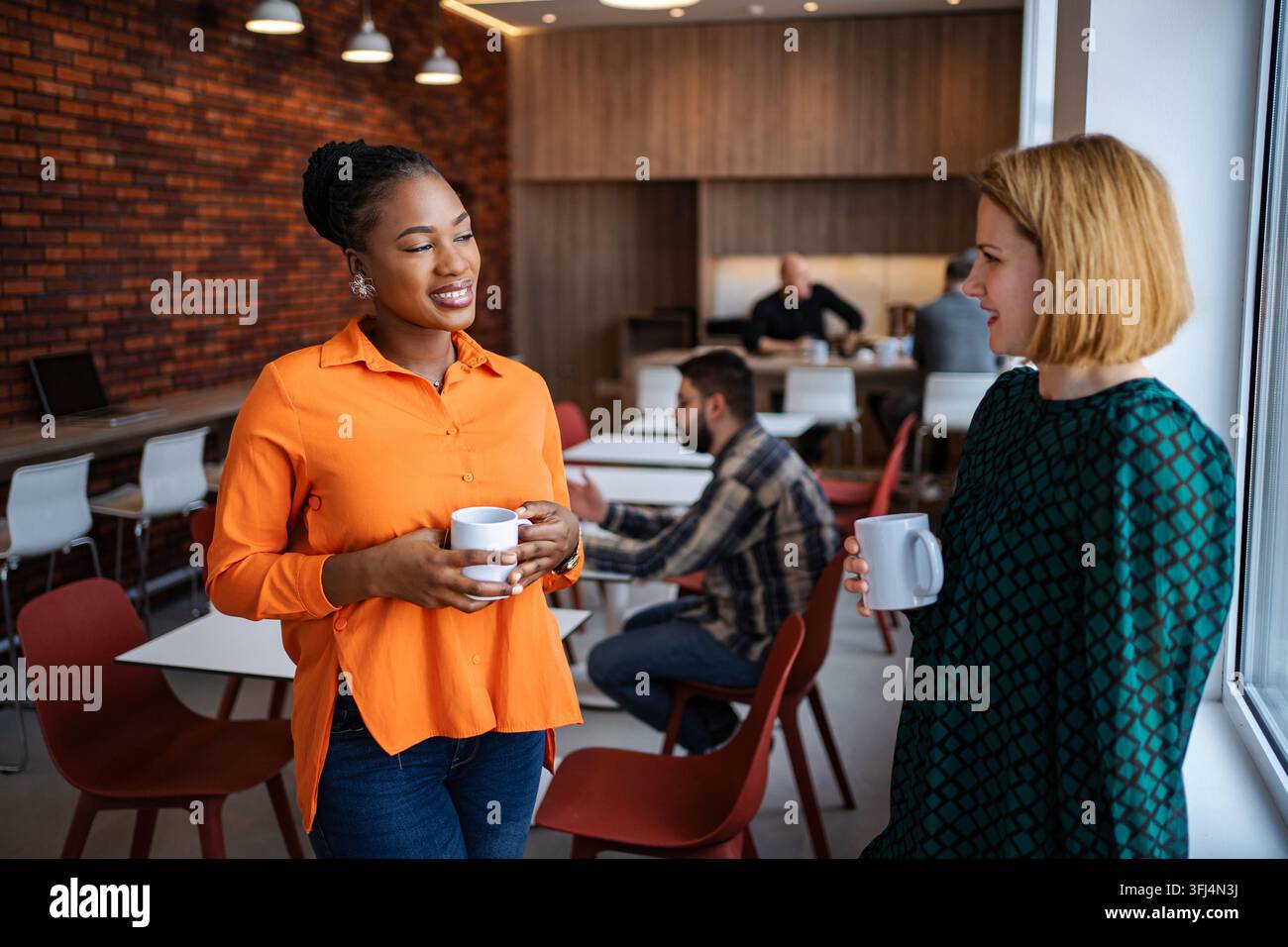 Diverse businesswomen discussing during coffee break in office Stock Photo