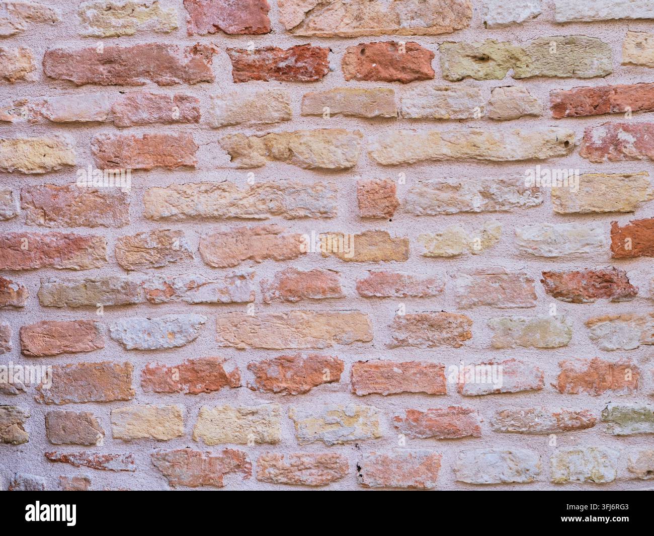 Wall made of different colored bricks Stock Photo