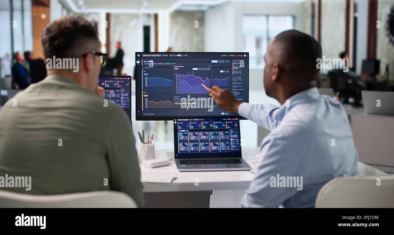 IT Specialist Carefully Monitors Server Performance Using Real-time Analytics Tools. Stock Photo