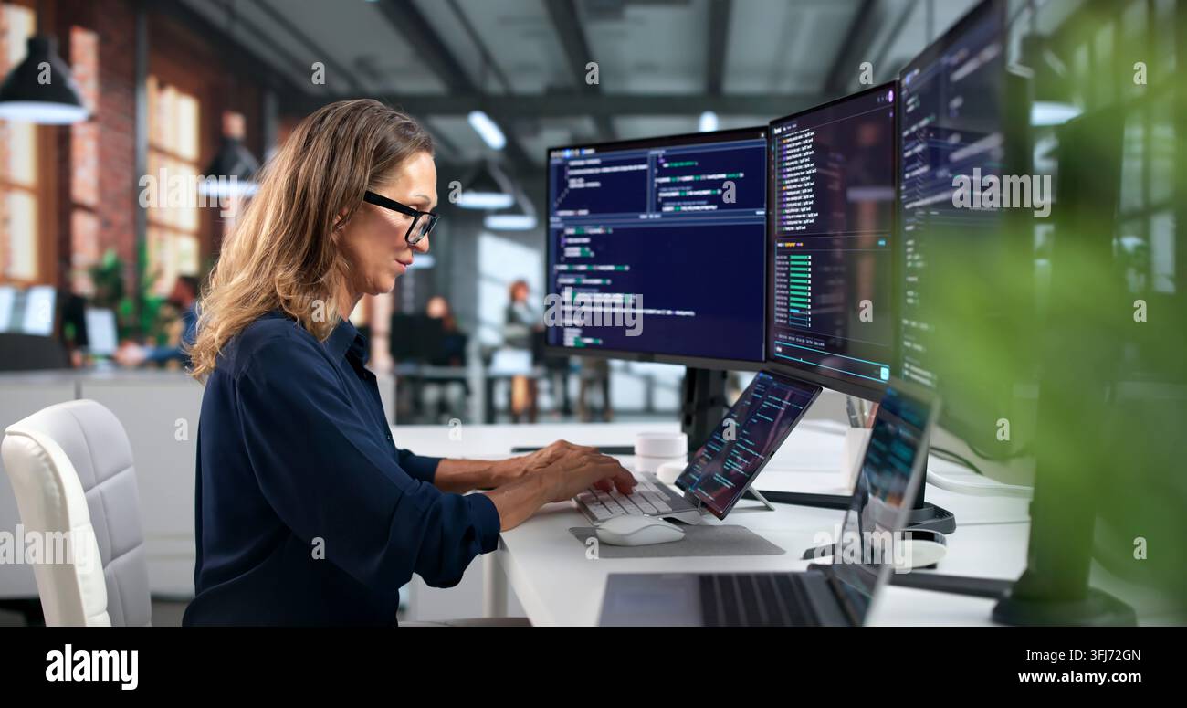 Software Developer Woman Coding Secure Programs On Laptop In Modern Workspace. Stock Photo