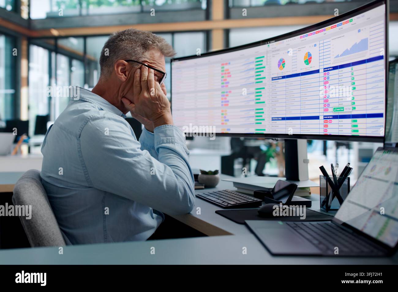 Chartered Accountant Tiredly Reviewing Complex Billing Codes On Computer Display. Stock Photo