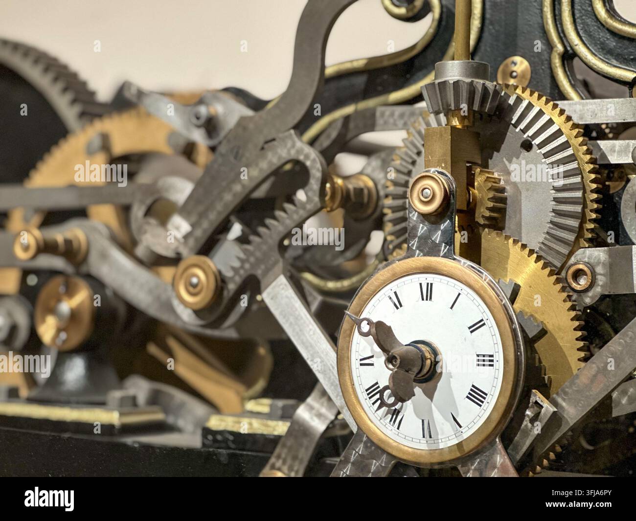 Detailed close-up of intricate mechanical clock gears and Roman numeral dial. Intricate close-up view of complex mechanical clock gears, cogs, and met - Smartphone Captured Stock Image