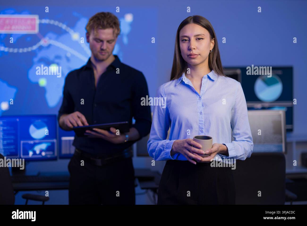 Cybersecurity professionals working collaboratively in a high-tech control room Stock Photo