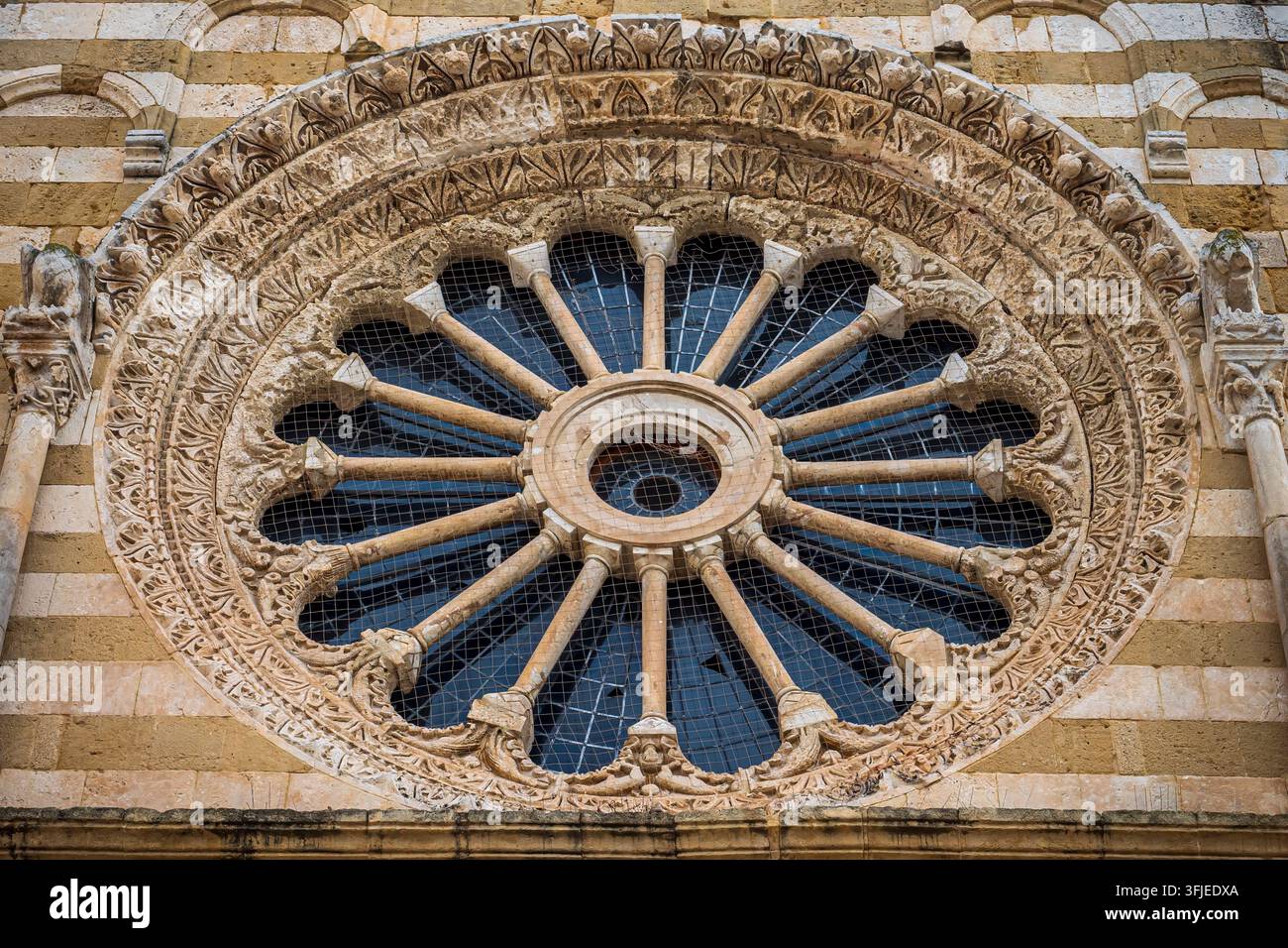 Close up view of a medieval rose window with historic stone carvings and patterns Stock Photo