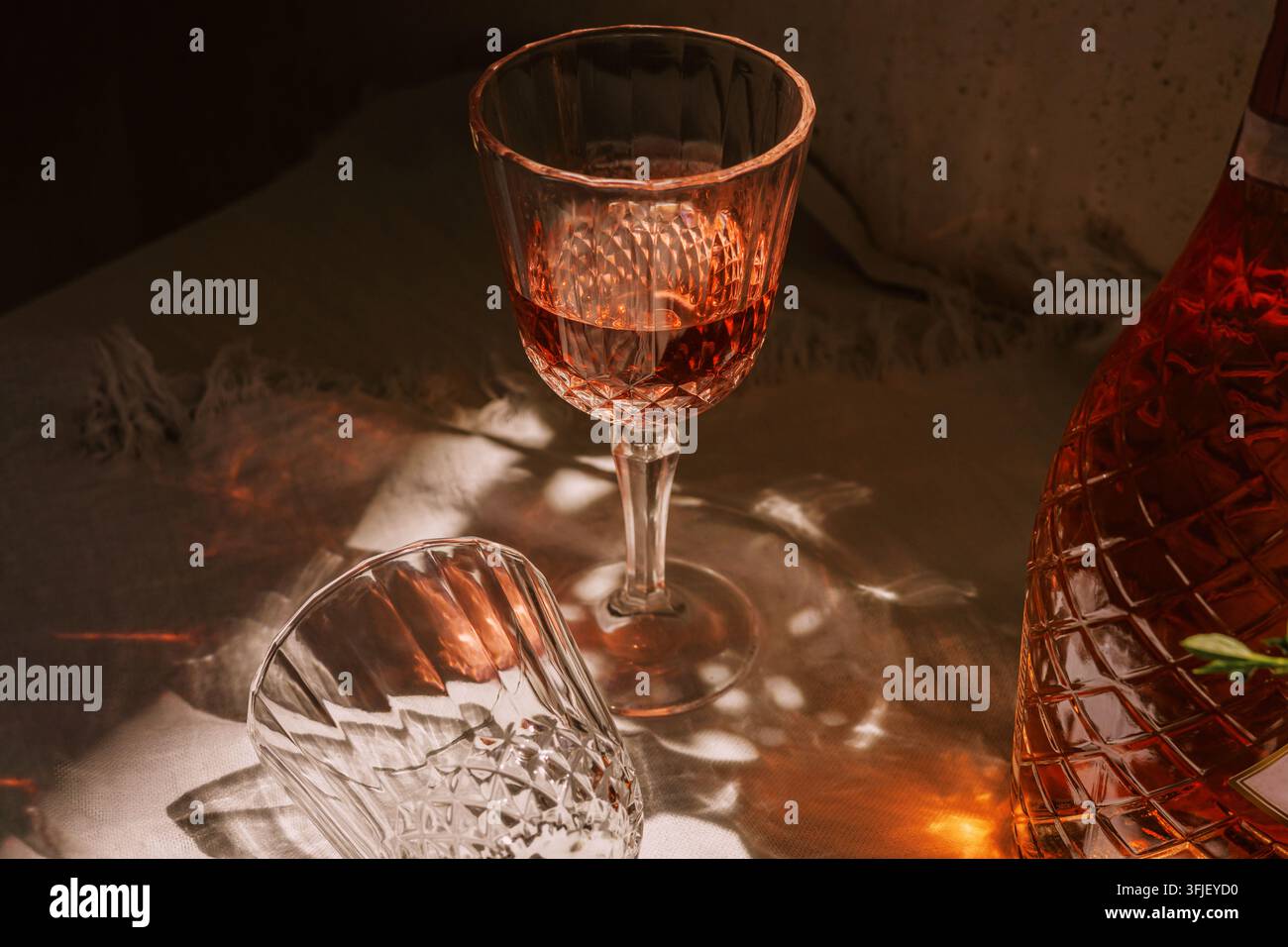 Rose Sparkling Wine Bottle and Crystal Glass in Cozy Restaurant Light Stock Photo