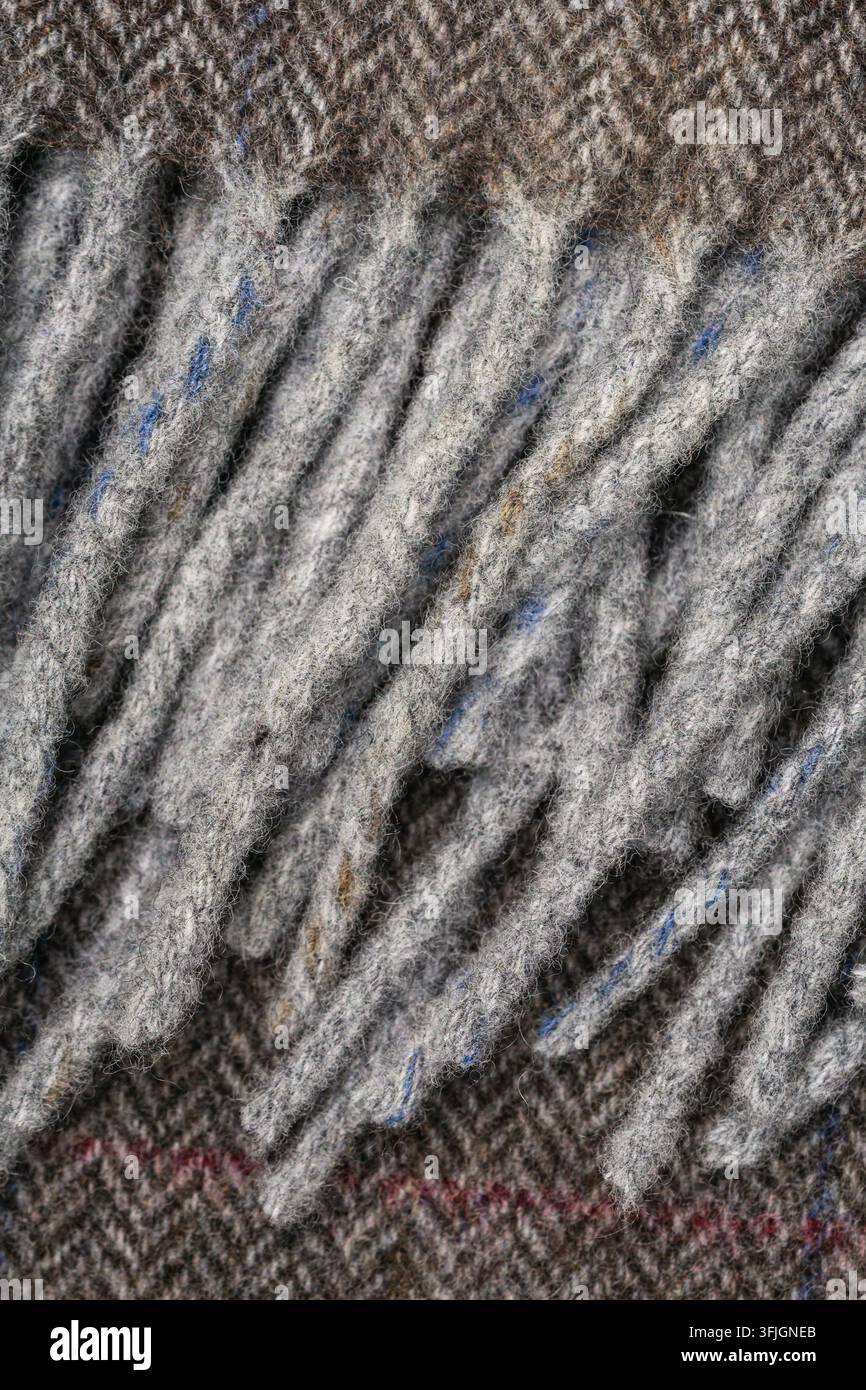 Abstract close-up showing dense gray textile fibers arranged in raised parallel ridges, with subtle blue and reddish threads visible in the textured m Stock Photo