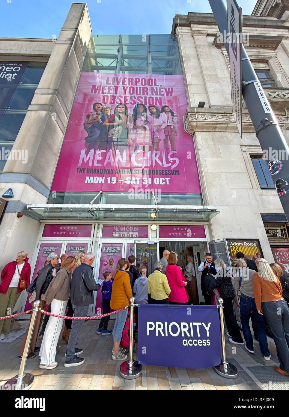 Priority access queue at Liverpool Empire Theatre on Lime Street for the musical Mean Girls, showing theatre-goers outside the venue. Stock Photo
