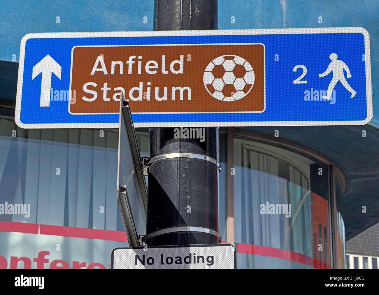 Brown pedestrian sign for Anfield Stadium in Liverpool, directing football supporters along a walking route to the ground,from the city centre Lime St Stock Photo
