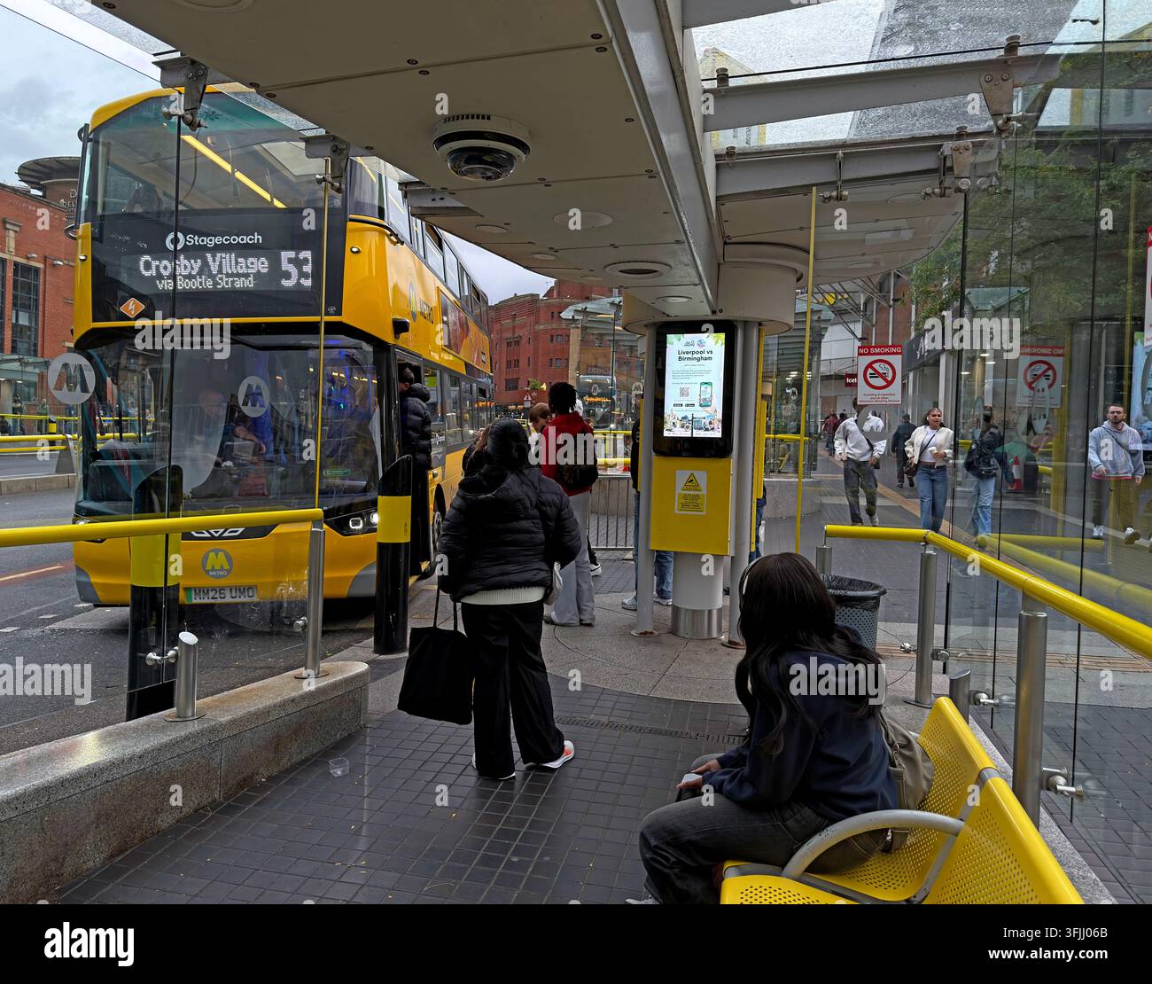 Passenger boarding a Liverpool City Region EV Wrightbus Electroliner Metro electric bus at Queen Square during the 2026 rollout of franchised services Stock Photo