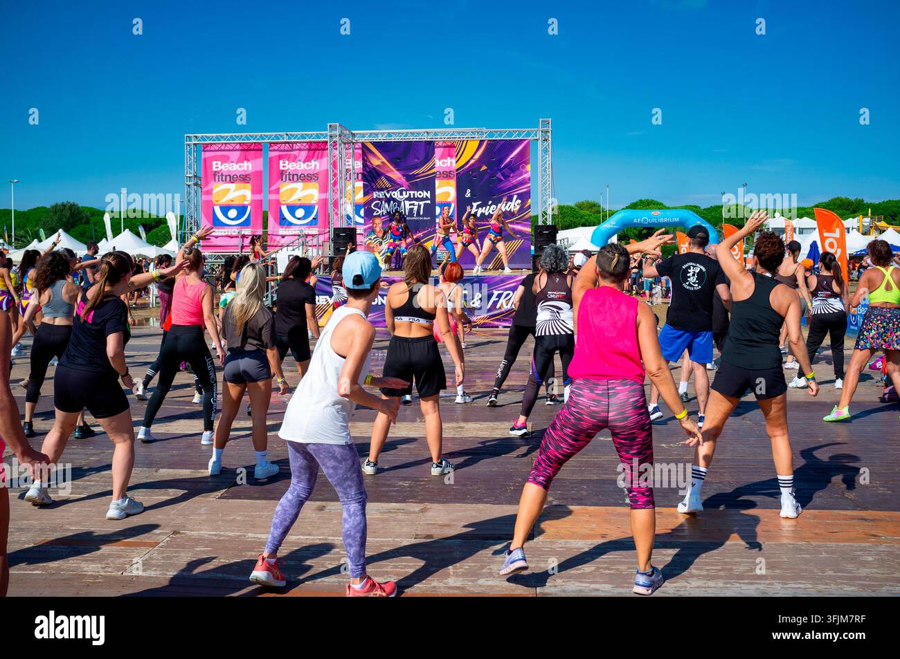 18 sept 2026 Bibione, Italy: Bibione Beach Fitness, A energetic group of people seen from behind participating in a large-scale outdoor fitness class Stock Photo
