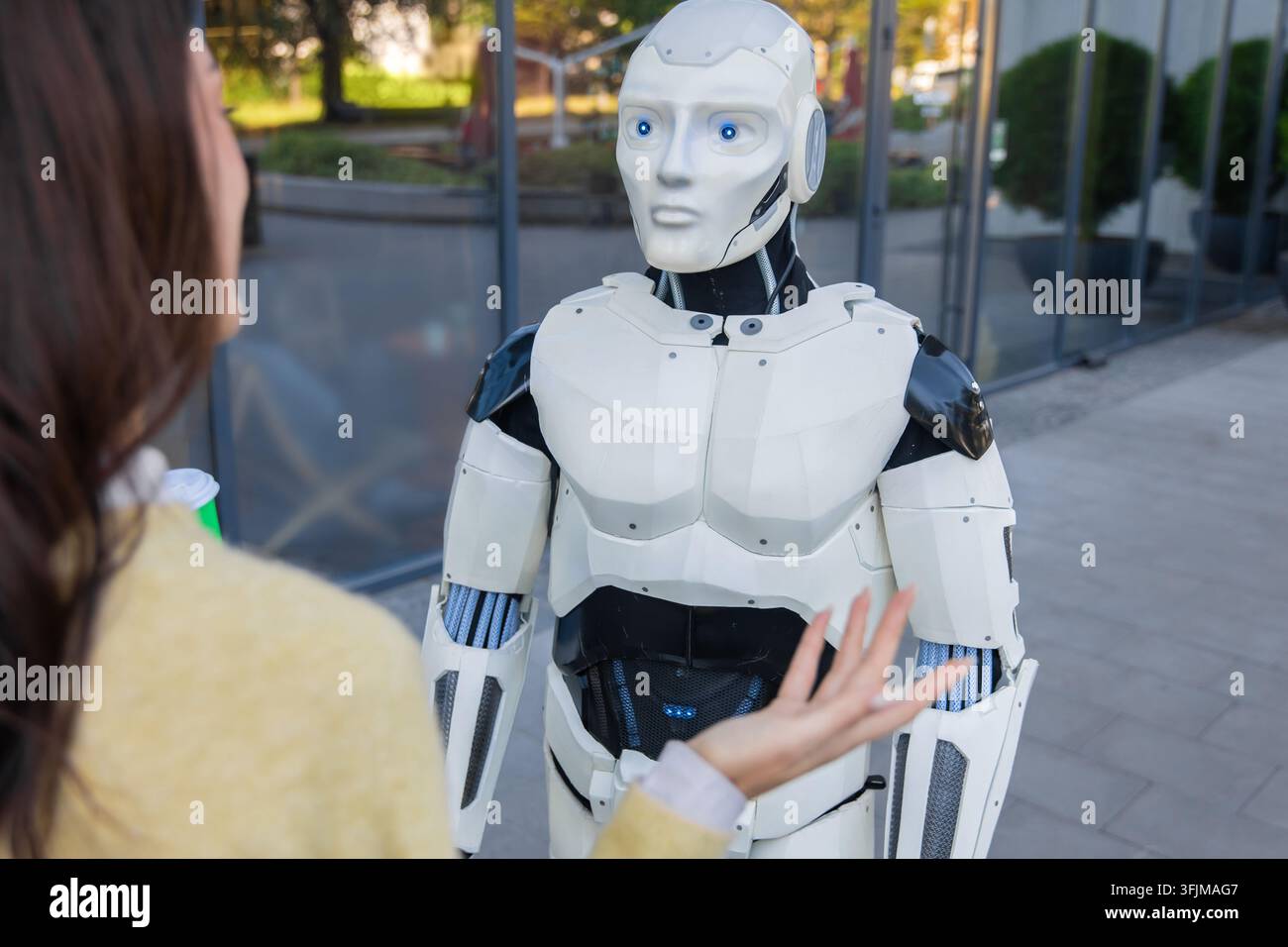 Futuristic robot looking at woman making hand gesture Stock Photo