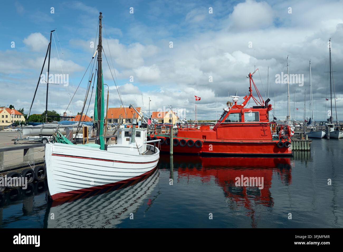 Fishing boats and a pilot boat docked in a harbor Stock Photo