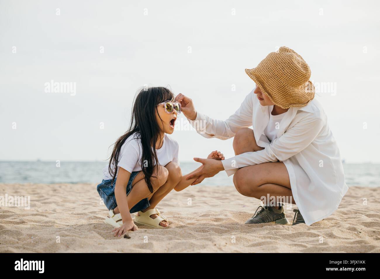 Happy family on beach vacation. Mother playing with daughter both ...