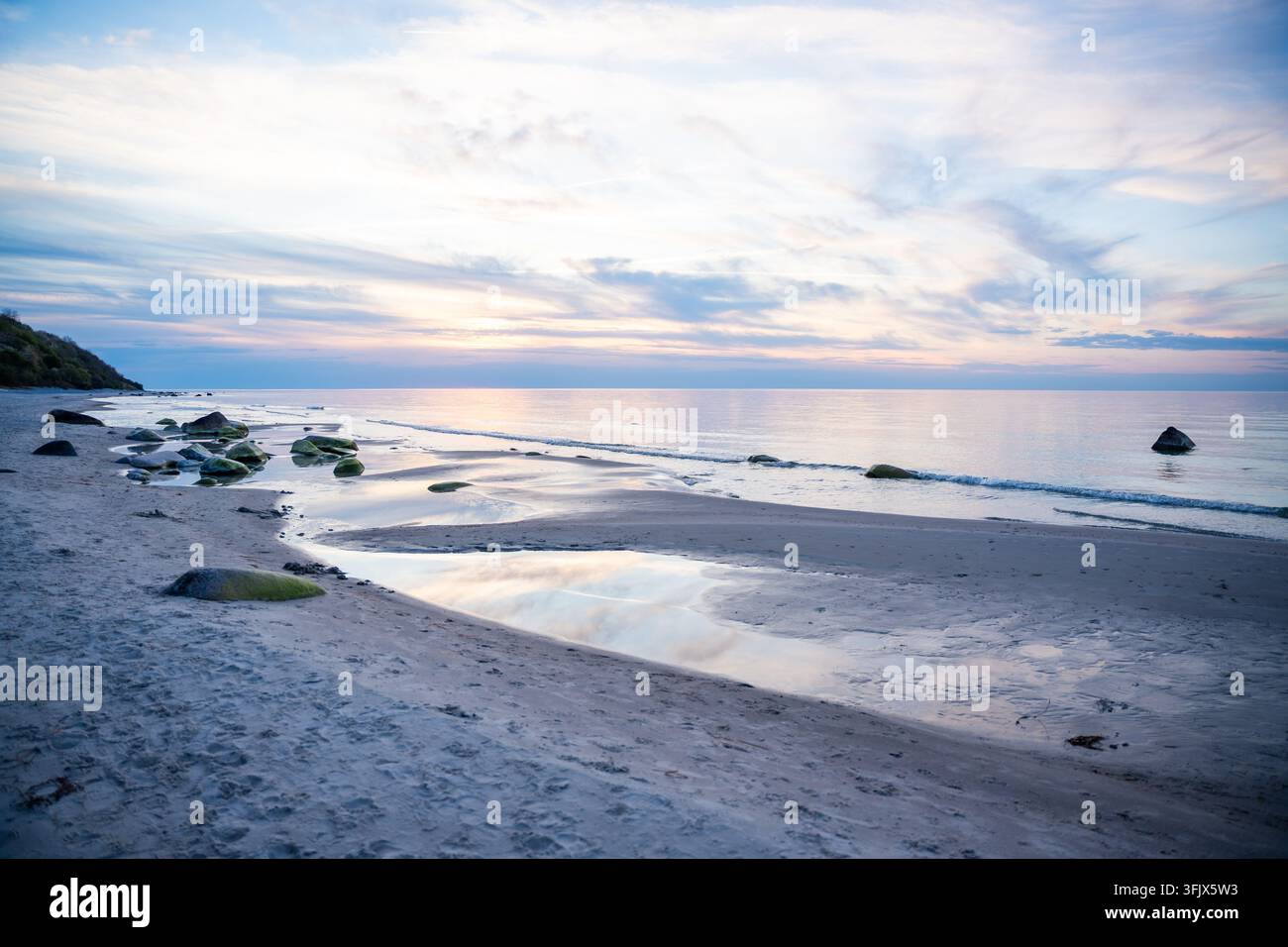 Rocky beach coastline on Ruegen island in Germany during sunset over ...