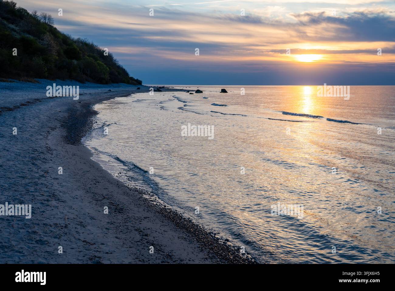 Rocky beach coastline on Ruegen island in Germany during sunset over ...