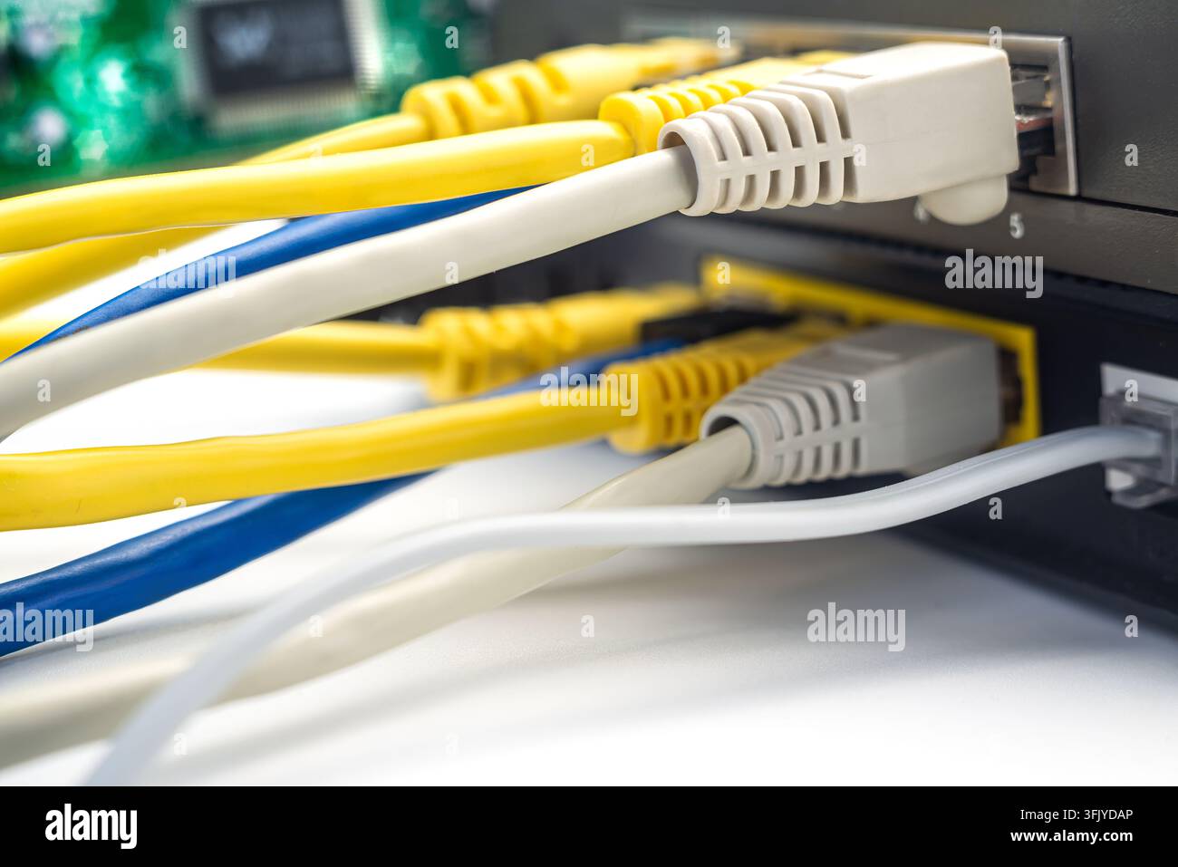 Several networking cables link to a router in a home office setting. The image shows close-up details of the cables. Stock Photo