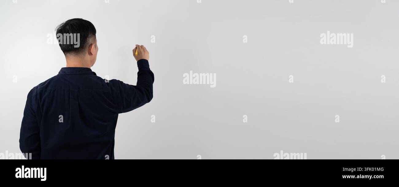 Man stands with back to camera, reaching out to touch blank white wall ...