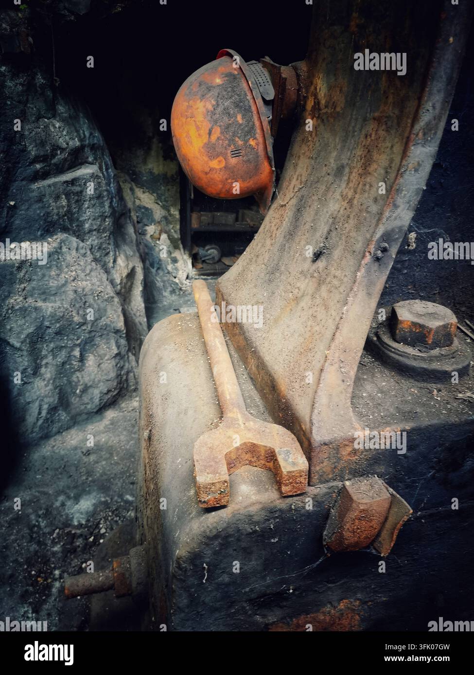 Hard hat and wrench on old machinery in mine - Smartphone Captured Stock Image