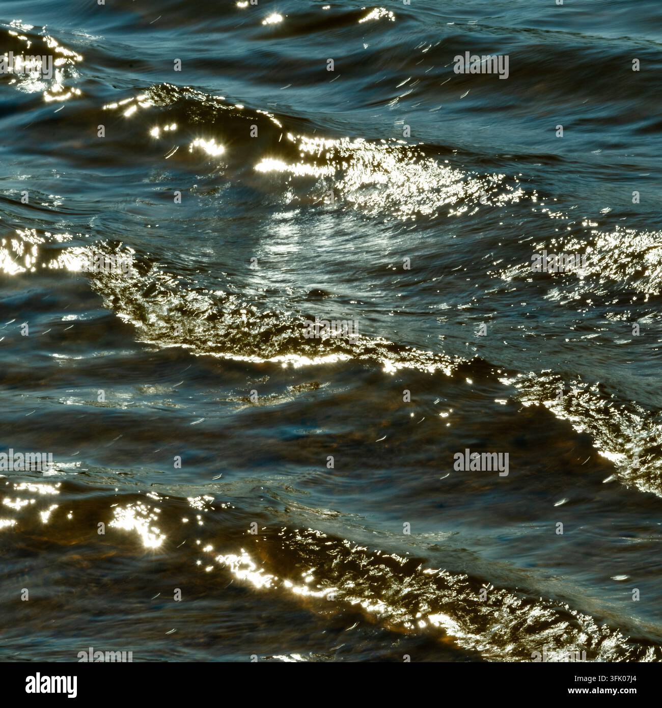 Bright sunlight glitters on rippling waves Stock Photo
