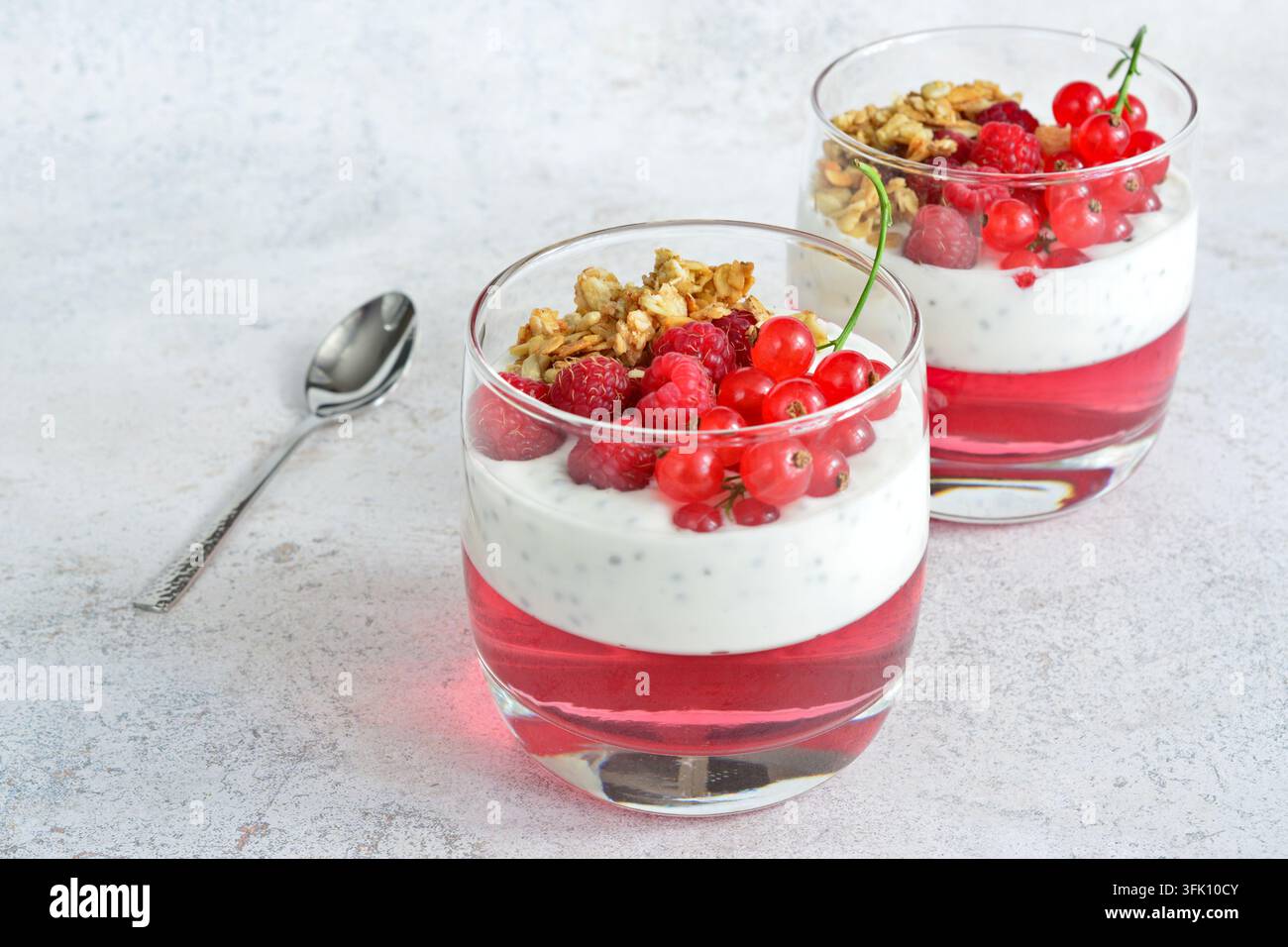 Raspberry and Red Currant Dessert Parfaits in drinking glass copy space Stock Photo