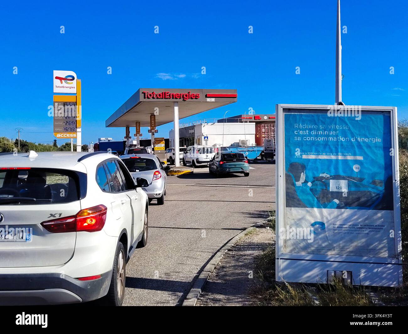 Fos Sign In A line of drivers waits to fill up at a Total gas station maintaining ...