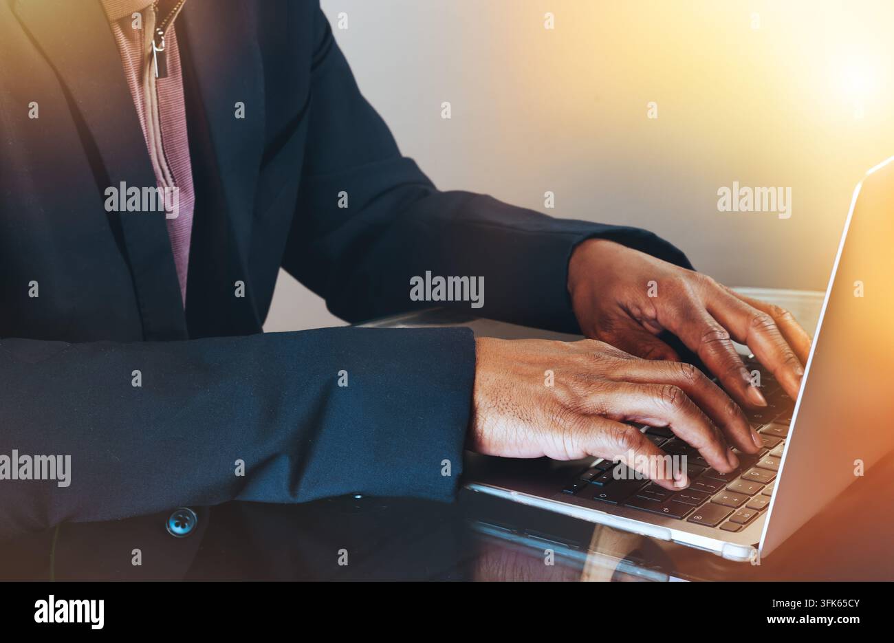 Close up of a businessman’s hands typing on a laptop in a professional setting. Stock Photo