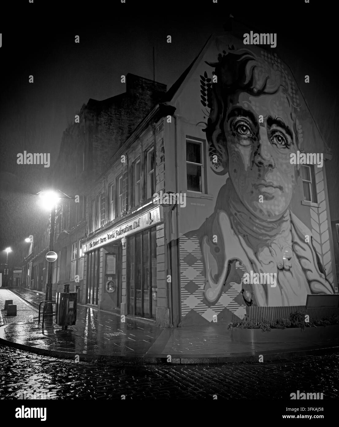 Rabbie Burns mural seen on a wet night in Kilmarnock, connecting the Ayrshire town with Scotland’s national poet and its famous 1786 edition. Stock Photo