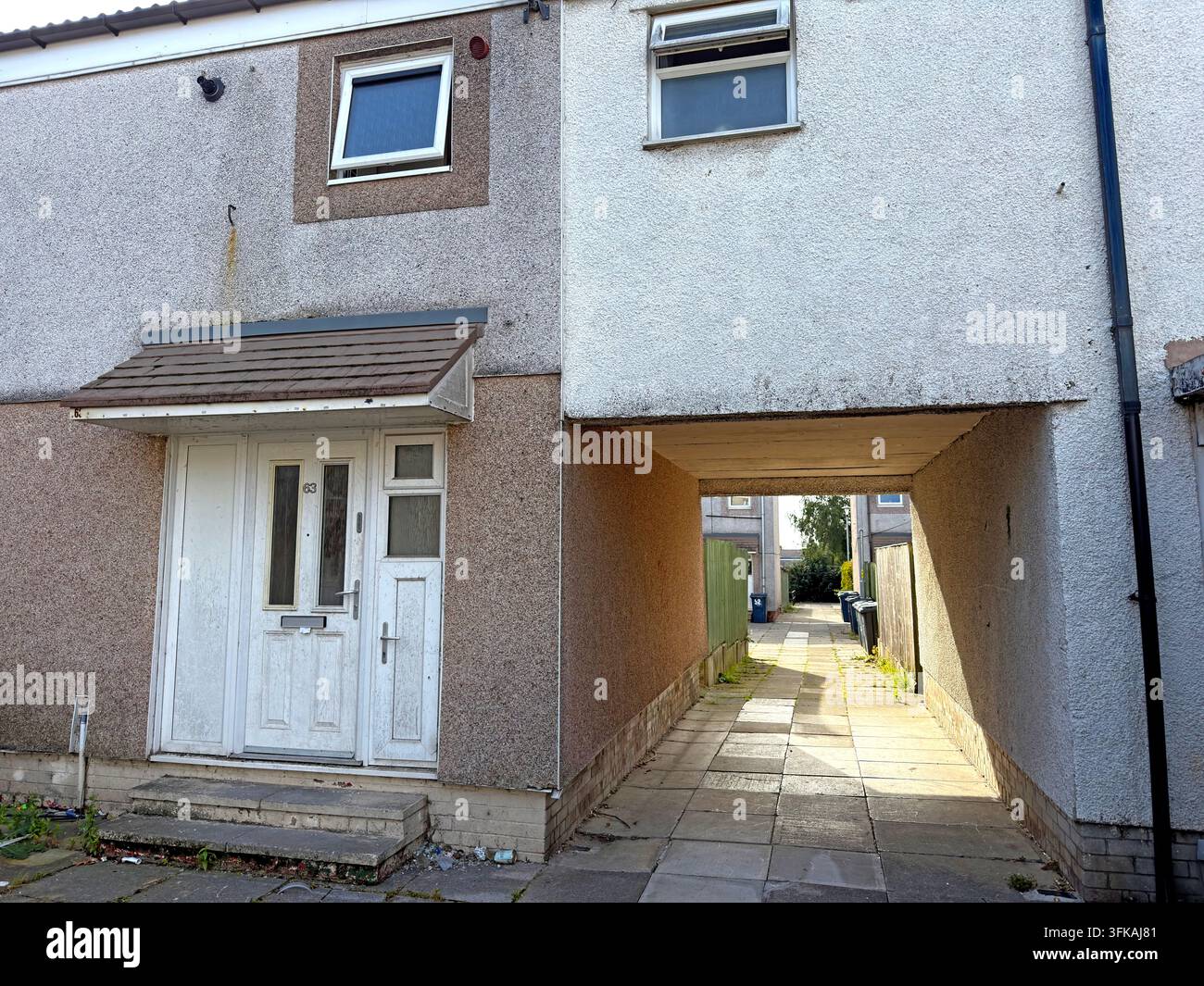 Social housing at Fairlie, Birch Green, Skelmersdale, with pebble-dashed New Town terraced homes and a covered pedestrian passage. Stock Photo