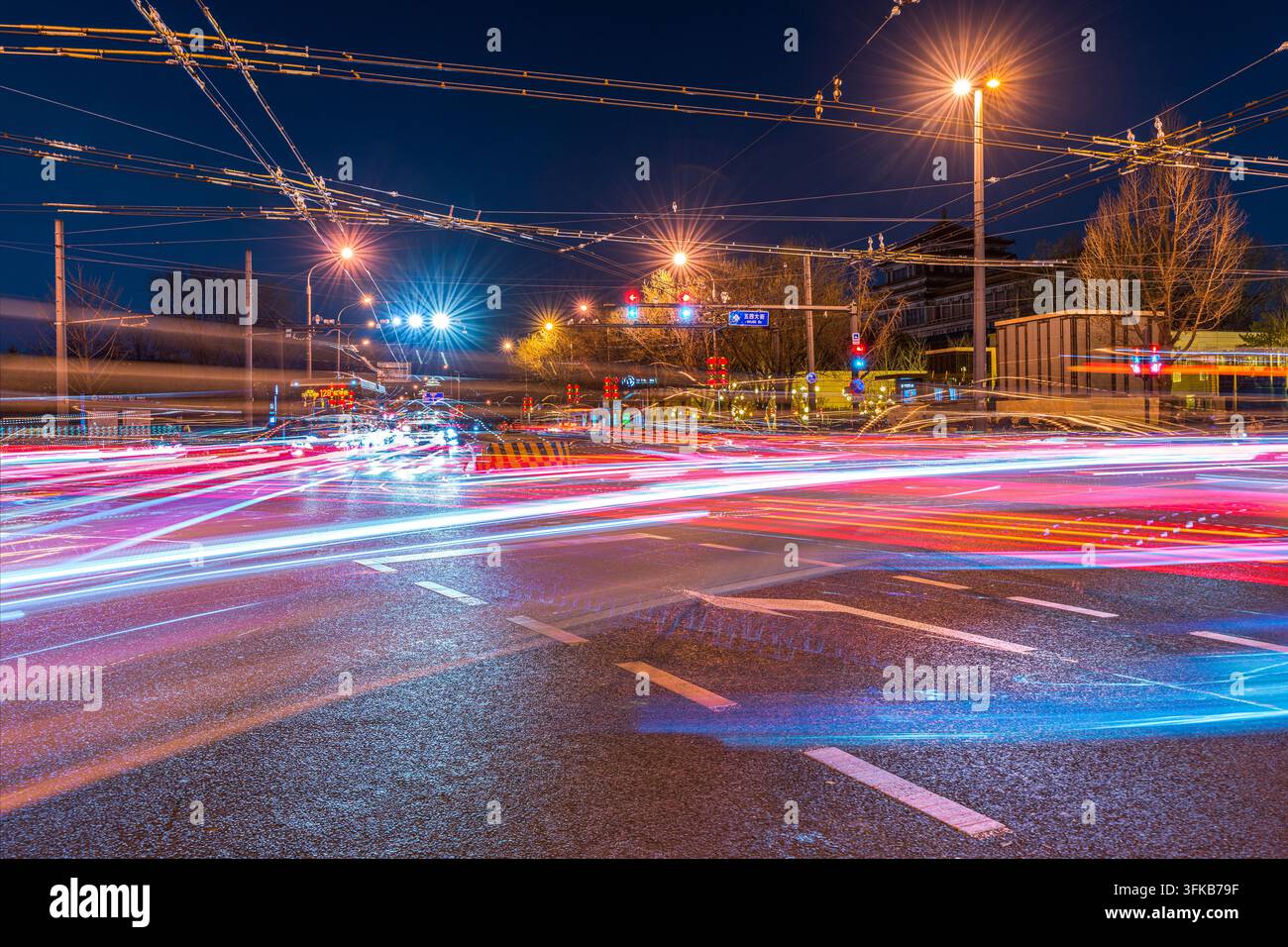 Light trails on busy intersection at night in Beijing Stock Photo