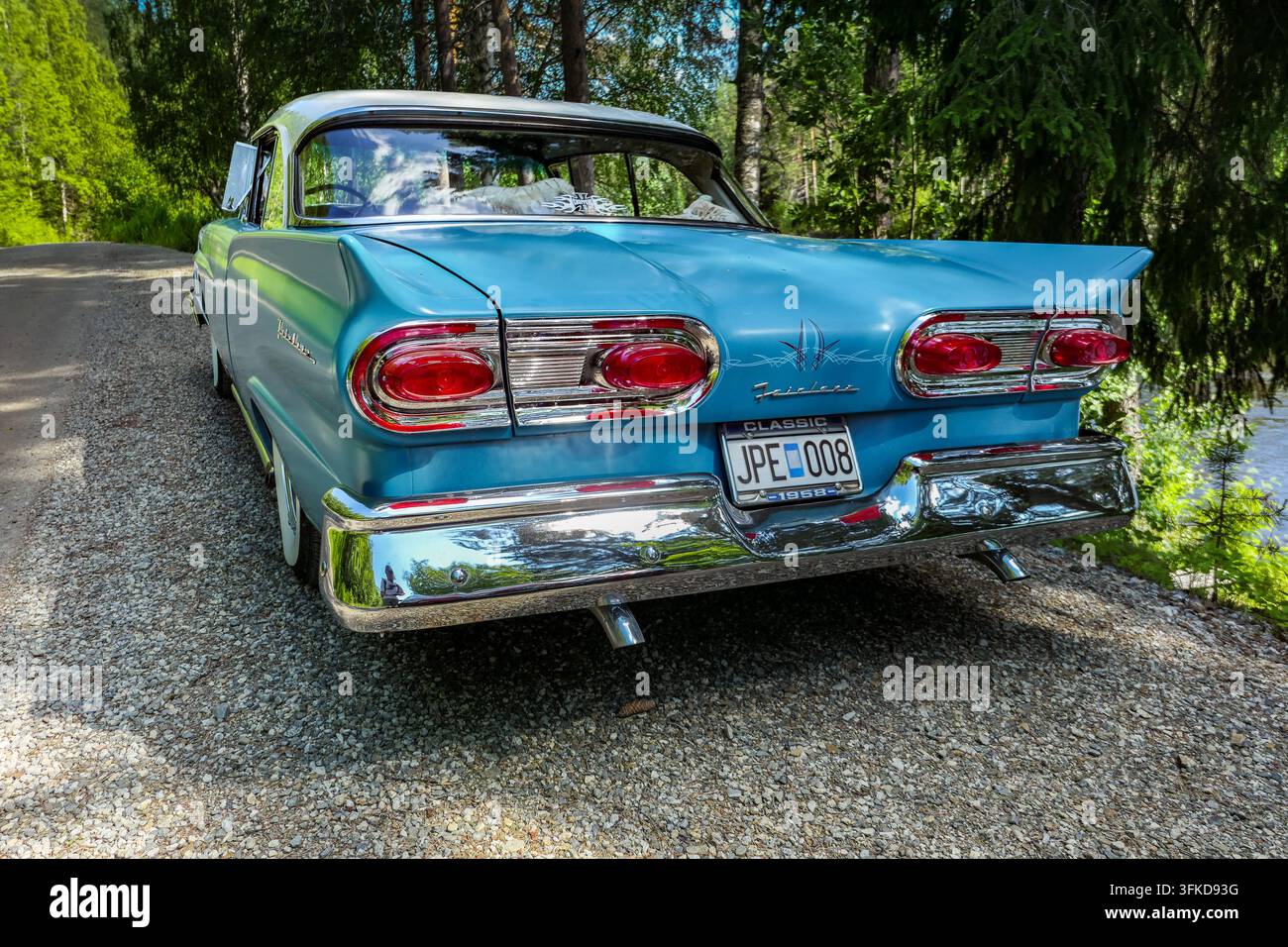 Beautifully restored turquoise classic car with dramatic tail fins and polished chrome Stock Photo