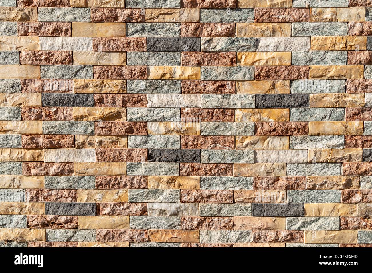 Multicolored stone brick wall arranged in horizontal course pattern. Stock Photo