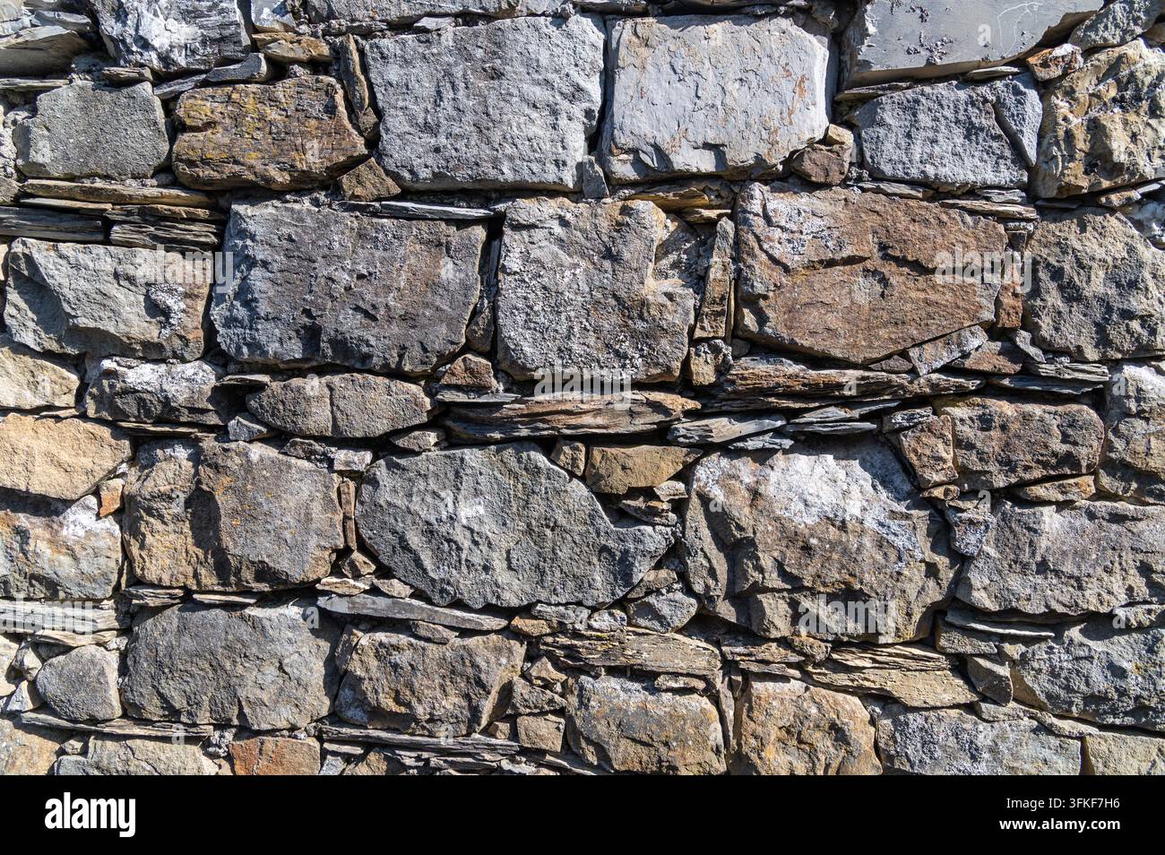 Stone wall with fitted rectangular blocks in outdoor facade. Stock Photo