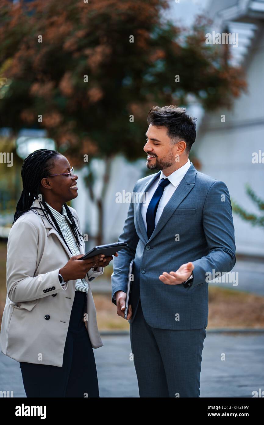 Diverse business professionals having informal meeting outdoors Stock Photo