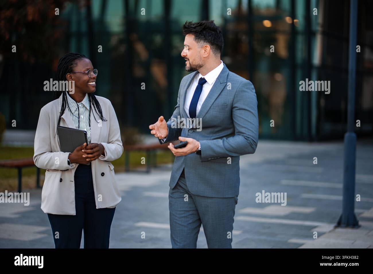 Diverse business professionals having informal conversation outdoors Stock Photo
